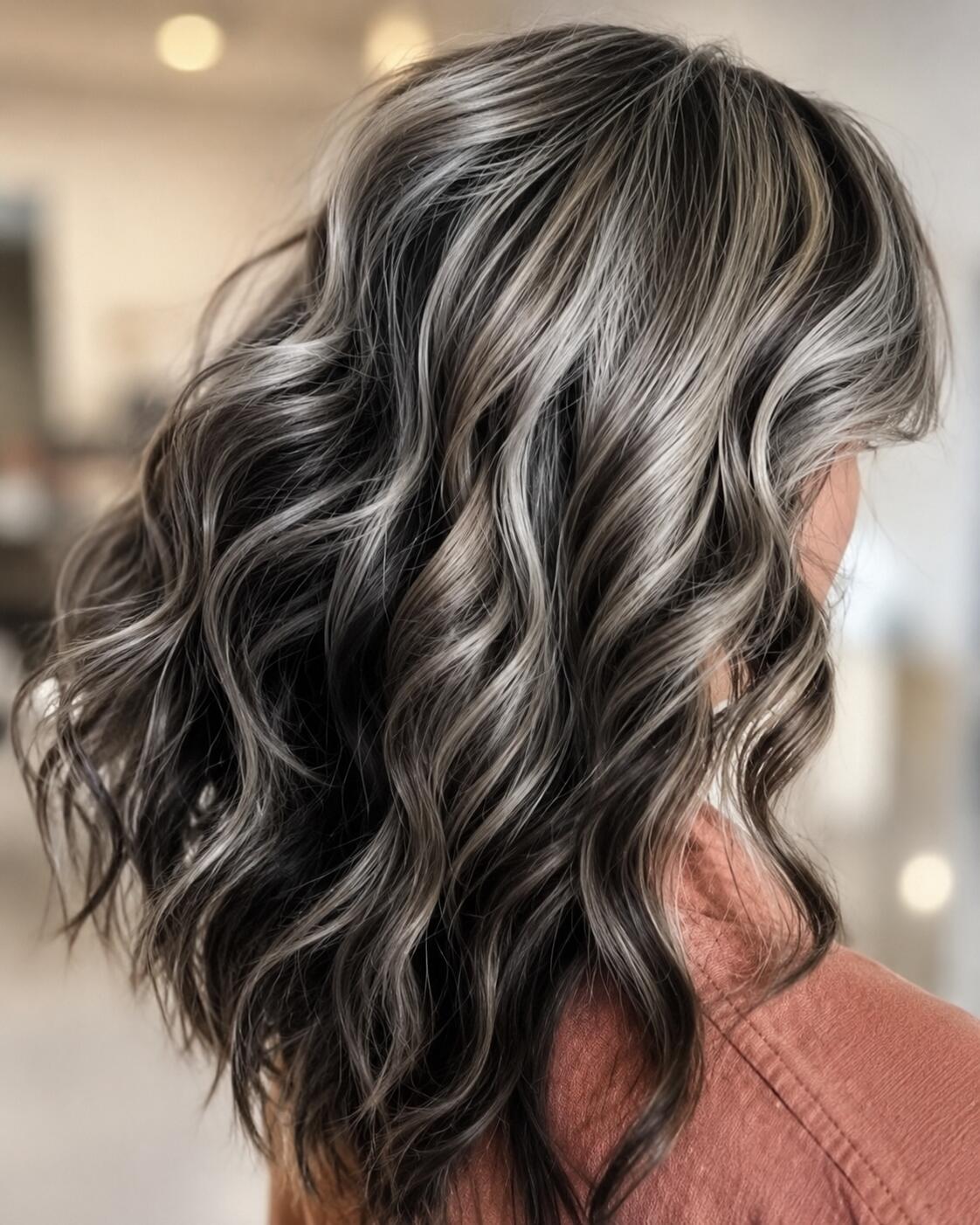 A wavy statement bob with bold silver streaks through dark hair